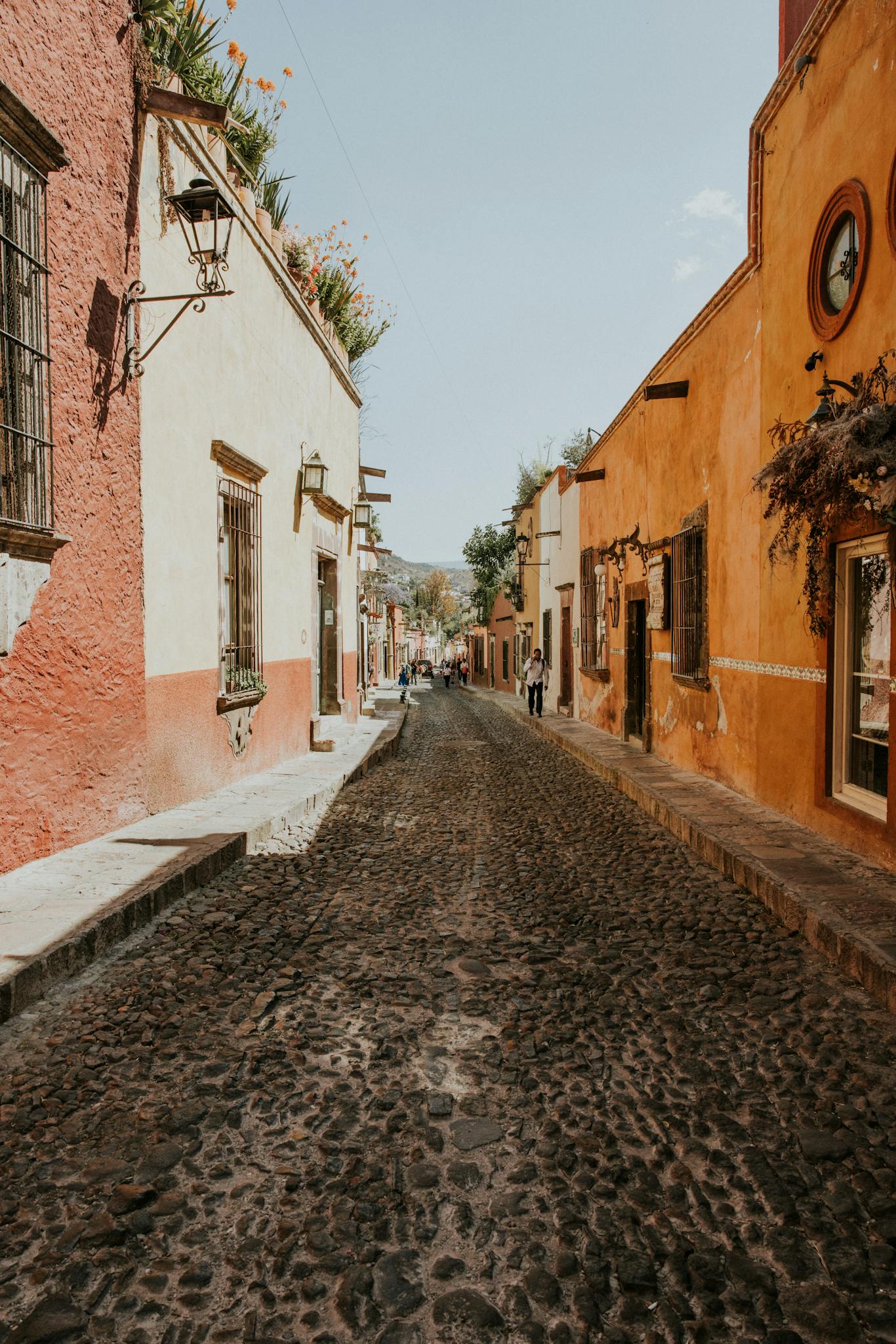 Cobblestone street in San Miguel de Allende, showcasing colorful colonial architecture.